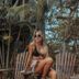 Pousada Fortal Jeri in Jijoca de Jericoacoara with a woman relaxing by tropical palms and wooden chairs