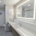 Hampton Inn Santa Clarita-Valencia bathroom with walk-in shower, vanity sink, and large lit mirror