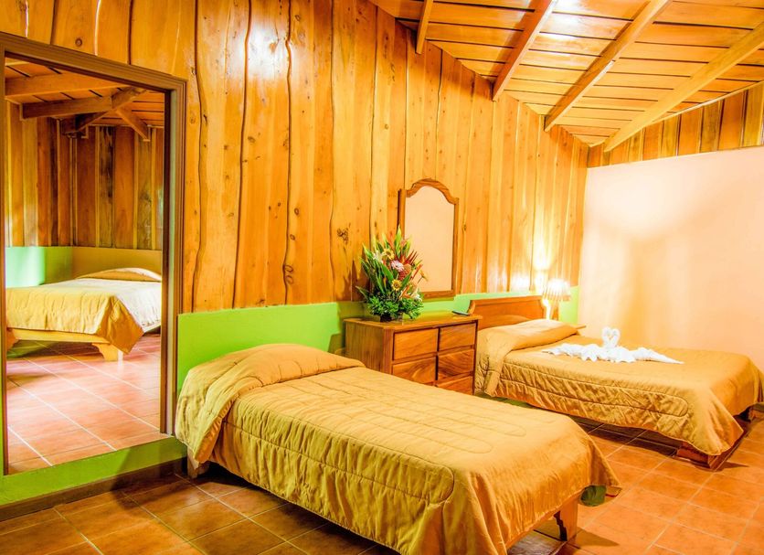 Hotel Cipreses Monteverde twin room with two beds, wood-paneled walls, and mirror
