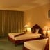 Majestic Oriental Hotel in Siem Reap guest room with twin beds, lamps, TV, and curtains