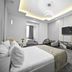 Imperial Palace Hotel Yerevan guest room with king bed, TV, seating area and modern ceiling lighting