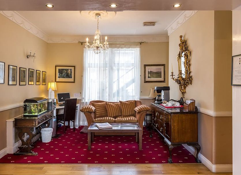 Uppercross House Hotel Dublin lobby with chandelier, sofa, desk and red carpet