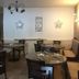 Hotel Le Centre in Brides-les-Bains dining room with round tables, chairs, and stone accent wall