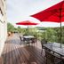 Hampton Inn By Hilton Elliot Lake terrace with red umbrellas, tables and forest view in Elliot Lake