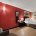 Quality Inn Wayne - Fairfield Area guest room with king bed, red accent wall and en suite bathroom door