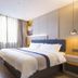 Motel168 Shanghai Qi Bao Inn in Shanghai room with a double bed, desk, and large window with curtains