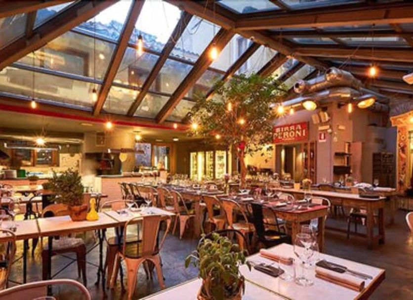 Do-Do Navona Suites in Rome dining room with glass roof, wooden tables, and hanging lights