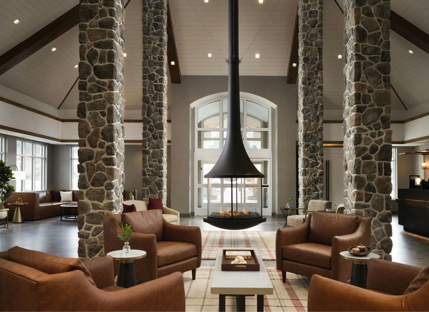 Inn at Bellefield / Hyde Park lounge with stone columns, leather chairs, and a central fireplace in Hyde Park