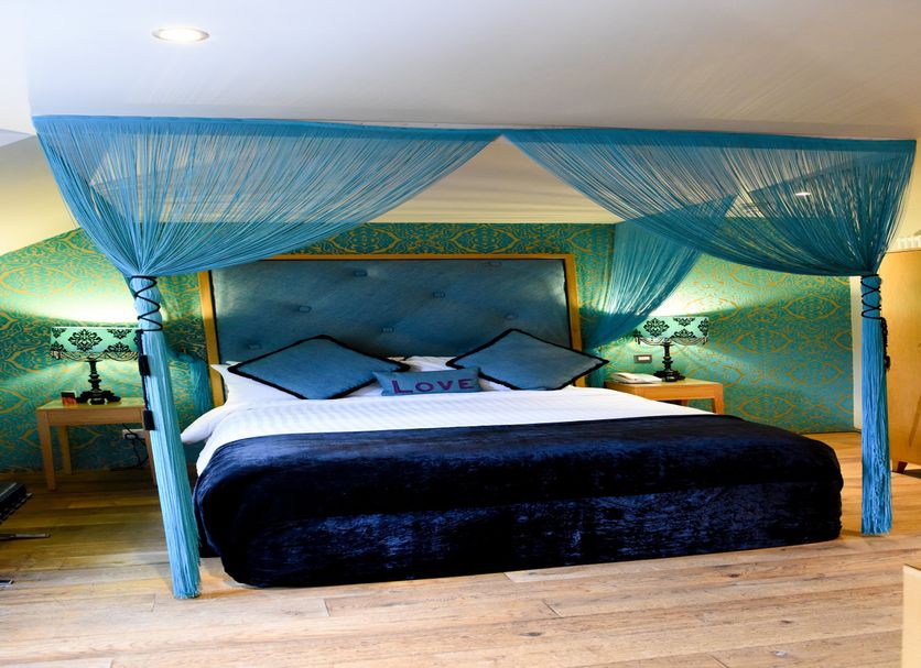 Glenskirlie Castle Hotel in Glasgow bedroom with four-poster bed and blue canopy