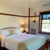 Shaker Village of Pleasant Hill in Harrodsburg bedroom with wood bed, lamp, and window light