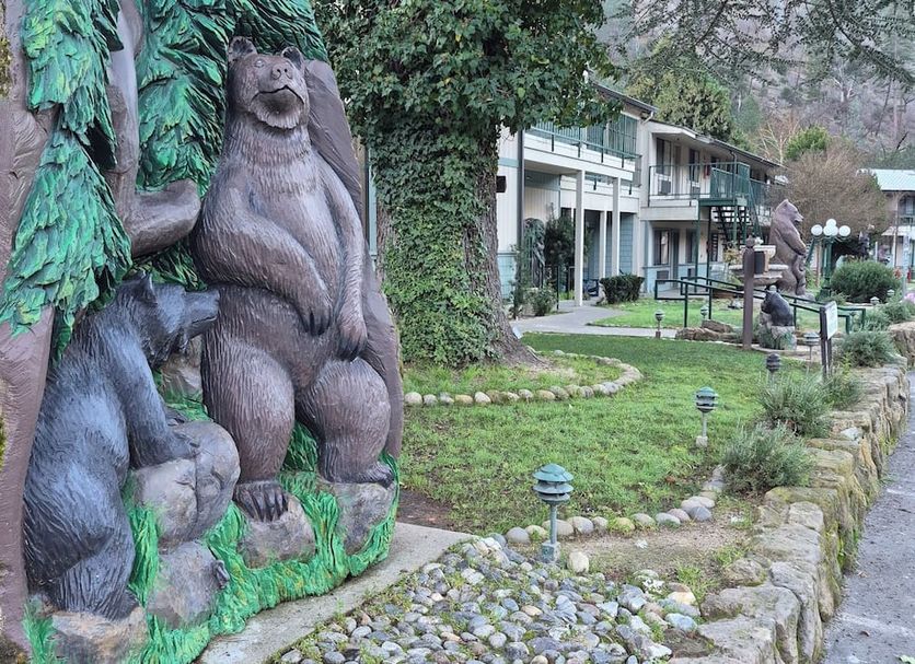 Cedar Lodge in El Portal with carved bear statues beside a landscaped garden path