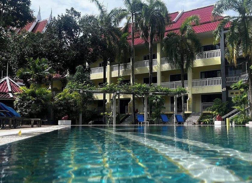 Mw Krabi Beach Resort in Ao Nang with palm trees beside a large outdoor pool and balcony rooms