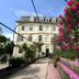 Hôtel des Eaux in Aix-les-Bains with a garden path and pink flowering bushes beside the hotel