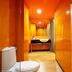 Yanjiang East Garden Inn in Guangzhou bathroom with orange walls, sink, toilet and shower curtain