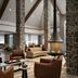 Inn at Bellefield / Hyde Park lobby with stone columns, hanging fireplace, and lounge seating