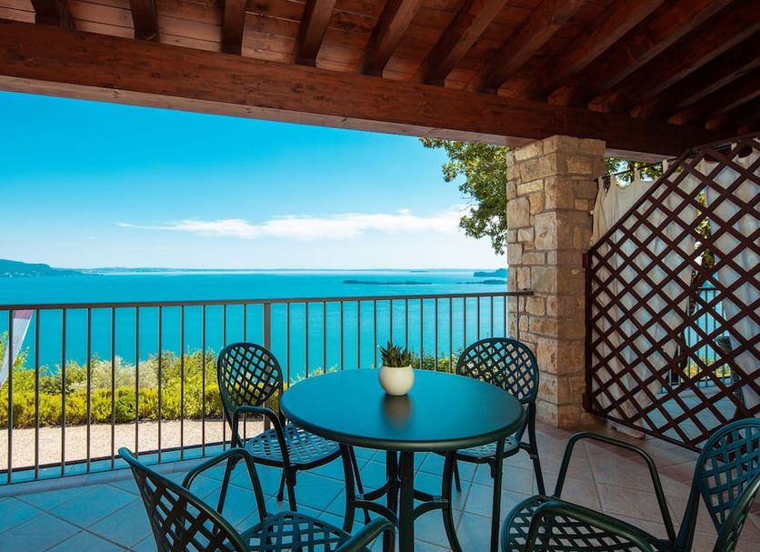 Domina Borgo degli Ulivi - Garda Lake terrace with table and chairs overlooking Lake Garda in Gardone Riviera