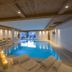 Residence Cesa Sassela indoor pool in Ortisei with lounge seating and mountain-view windows