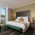 Leonardo Hotel Offenbach Frankfurt room with city view, large bed, and seating area in Offenbach am Main