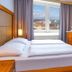 Hotel Uno Prague guest room with twin beds, bedside lamps, and city view through the window