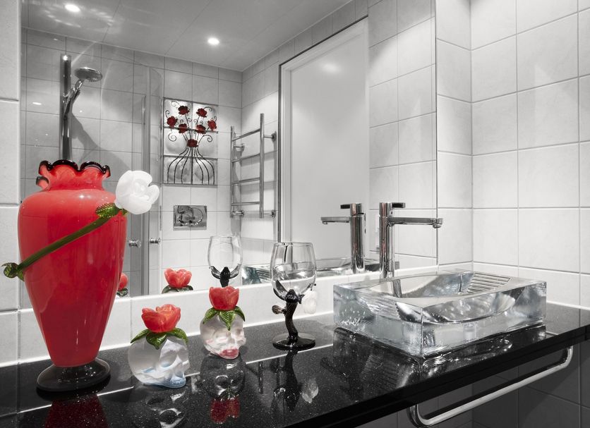 Kosta Boda Art Hotel bathroom in Kosta with glass vessel sink, black vanity, red art decor and tiled shower