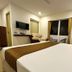 Hotel Ramakrishna in Mahabalipuram guest room with bed, chair, wall-mounted TV and balcony doors