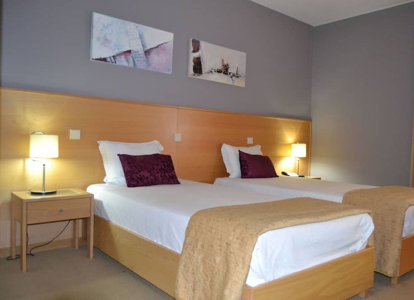 Hotel Bienestar Termas de Moncao room in Monção with twin beds, bedside lamps, and wall art
