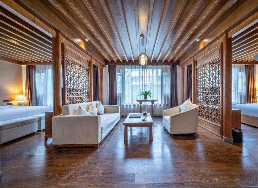 Lijiang Tianyu Boutique Hotel in Lijiang: spacious guest room with wood ceiling, sofa seating, and twin beds