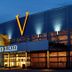 Hotel Noordzee in Katwijk exterior at dusk with illuminated glass facade and large V sign