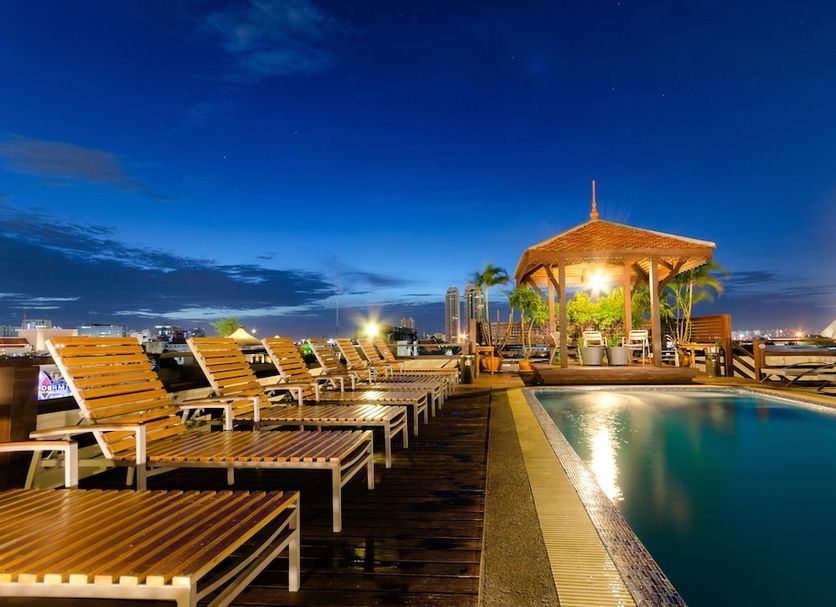 Khaosan Palace Hotel Bangkok rooftop pool with lounge chairs and lit gazebo at dusk