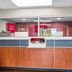 Red Roof Inn Richmond - Airport Sandston front desk with glass office window and wood-paneled counter