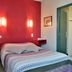 Logis Auberge des Vieux Chênes room in La Chapelle-aux-Brocs with bed, red accent wall and wall lights