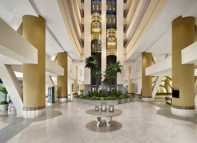 The Westin Resort Guam in Tamuning lobby atrium with tall gold columns, palm trees, and marble floors