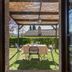 Le Rocche di Valiano in Vagliagli: outdoor patio table set in a garden with pergola shade