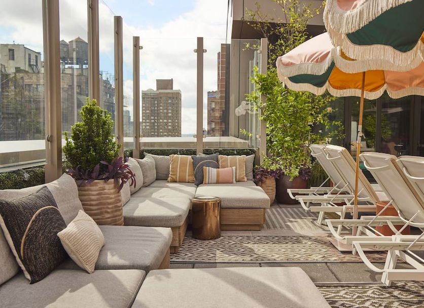 Royalton Park Avenue rooftop lounge in New York with cushioned seating and striped sun loungers