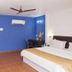 Le Pearl Goa Resort & Spa Vagator guest room with king bed, balcony door, and blue accent wall
