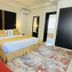 Hotel Del Pescador in Ajijic guest room with king bed, patterned rug, and balcony door