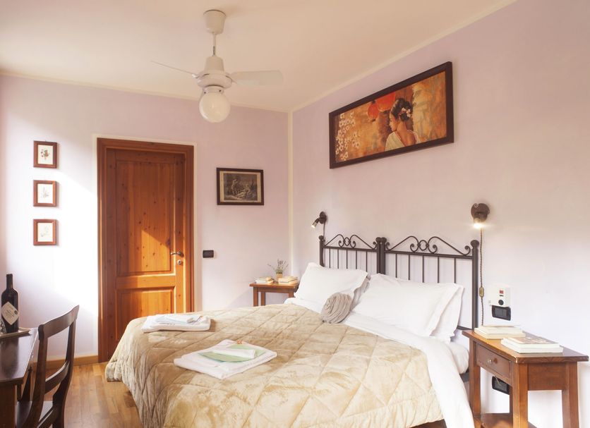 Agriturismo Il Cavicchio in Pianoro guest room with wrought-iron bed, bedside tables, and wooden door