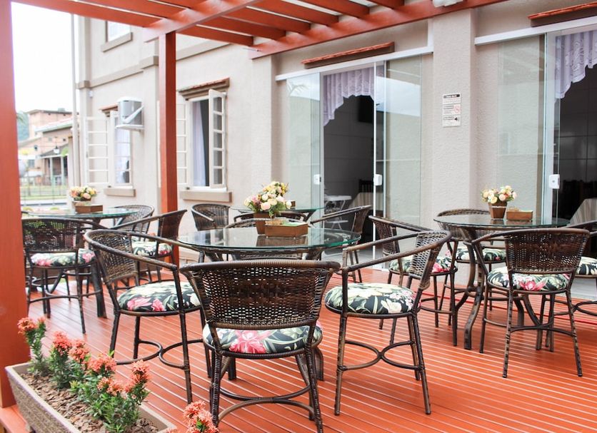 Pousada Casarão Schmidt in Pomerode with an outdoor terrace, wicker tables and chairs, and pergola seating