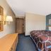 Super 8 by Wyndham Potosi guest room with king bed, blue accent wall, and desk
