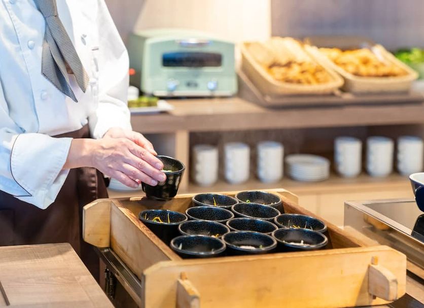 Premier Hotel Cabin Shinjuku in Tokyo, chef preparing bowls at a breakfast buffet station