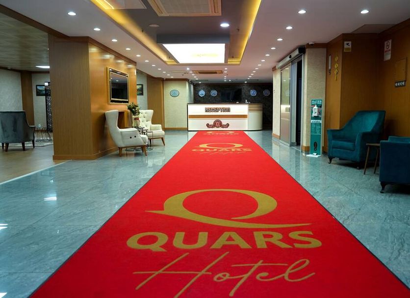 Quars Garden Hotel lobby in Düzce with red carpet, reception desk, and blue lounge chairs
