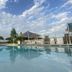 Aqua Resort in Diani Beach features a serene outdoor pool with loungers and shaded seating under a cloudy sky.
