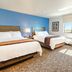 My Place Hotel-Idaho Falls room with two beds, blue accent wall, and window view in Idaho Falls