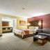 Red Roof Inn Vincennes room with bed, striped sofa, coffee table and lamp
