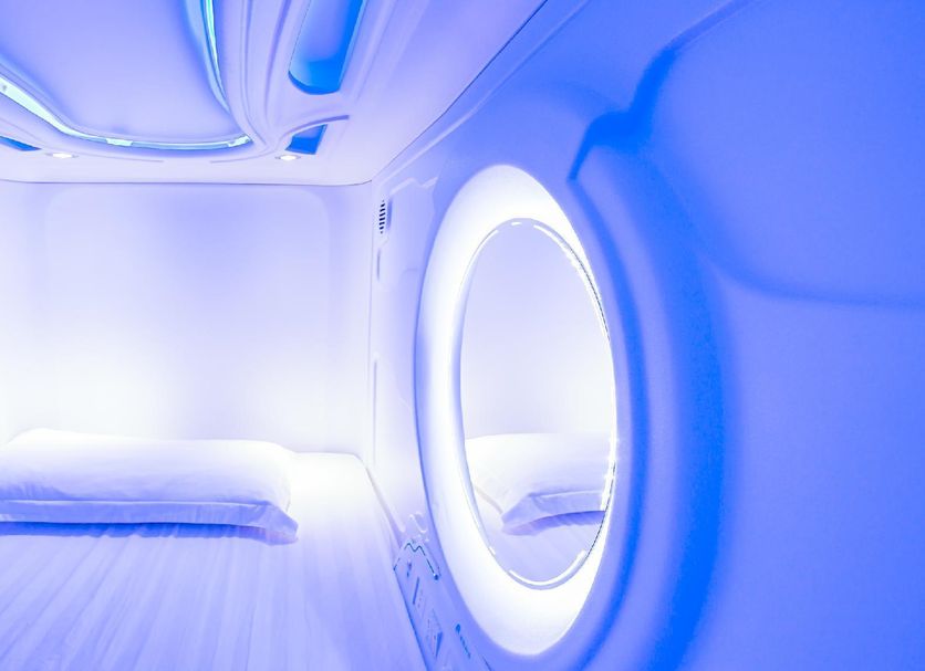 Spacepod@lavender in Singapore: futuristic capsule pod bed with oval window and blue lighting