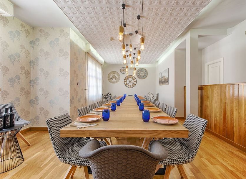 Hostal Zahara, Ferrol: long dining table in a bright restaurant with woven chairs and pendant lights