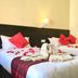 Katero in Pokhara: twin beds with rose petals, towel swans, and red bedding
