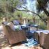 Outdoor patio seating at Bella Vista Bed and Breakfast in Placerville with wicker chairs and a table under trees