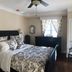 The Carriage House in Ocean Grove: guest room with floral bedding, dresser, and window