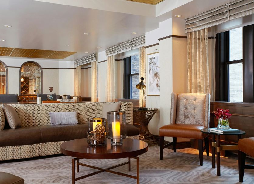 Westhouse Hotel New York lounge with sofa, armchair, coffee table and city windows in New York